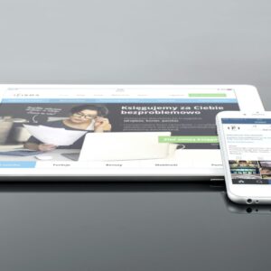 Modern tablet and smartphone displaying web content on a reflective surface, highlighting technology and connectivity.